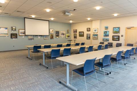Johnson Community Room with tables and chairs facing screen